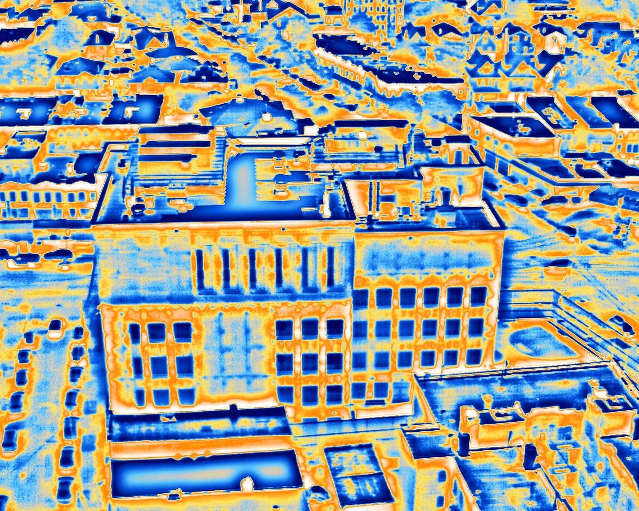 The same aerial thermal frame in the arctic palette, cool areas in blue and warm areas in yellow and white